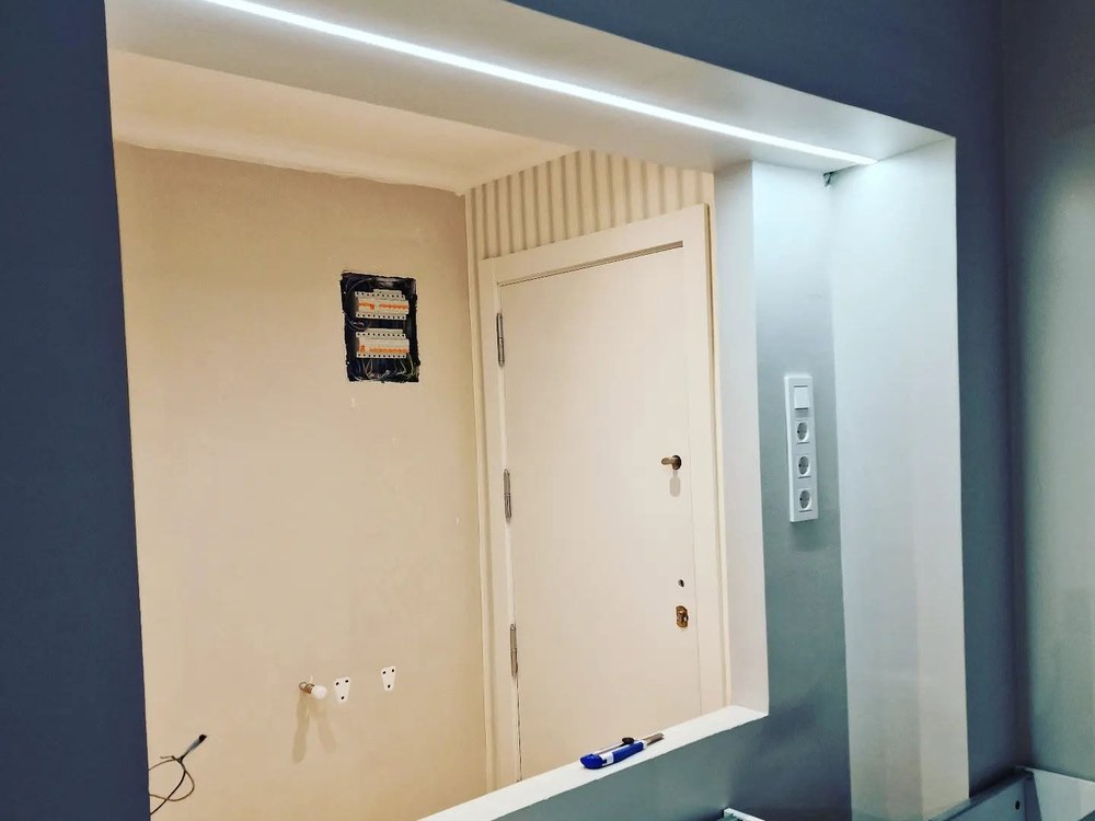 Entrada de vivienda con luz lineal empotrada y cuadro nuevo