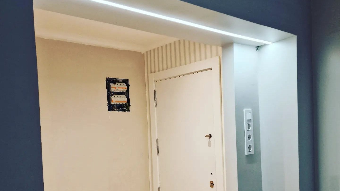 Entrada de vivienda con iluminación lineal LED y cuadro nuevo instalado