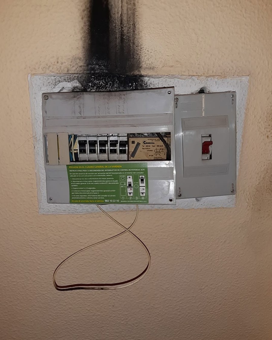 Cuadro eléctrico antiguo con la pared quemada por encima